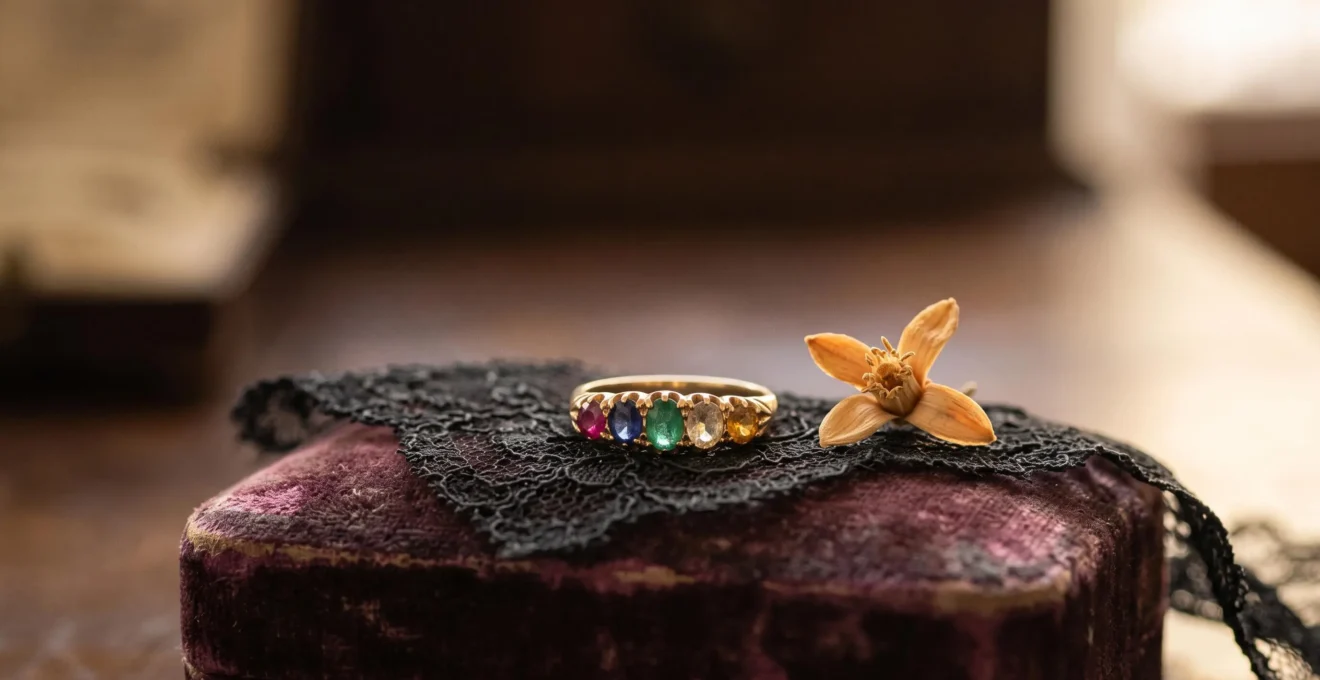 Anillo victoriano antiguo con gemas de colores brillando sobre un fondo de encaje oscuro, evocando un mensaje de amor oculto